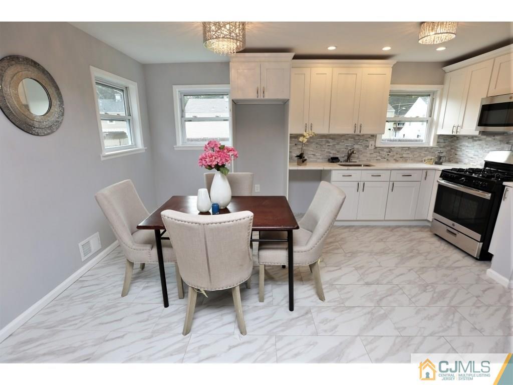 173 McFarlane Road Colonia, NJ 07067 - Photo 18 of 25 a kitchen with a dining table chairs and white cabinets
