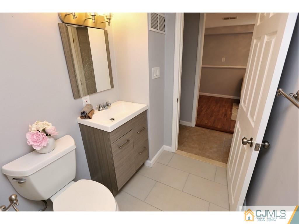 173 McFarlane Road Colonia, NJ 07067 - Photo 22 of 25 a bathroom with a sink vanity mirror and toilet