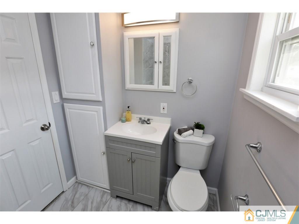 173 McFarlane Road Colonia, NJ 07067 - Photo 24 of 25 a bathroom with a sink a toilet and a mirror