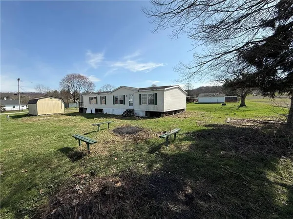 a view of a house with a yard and sitting area