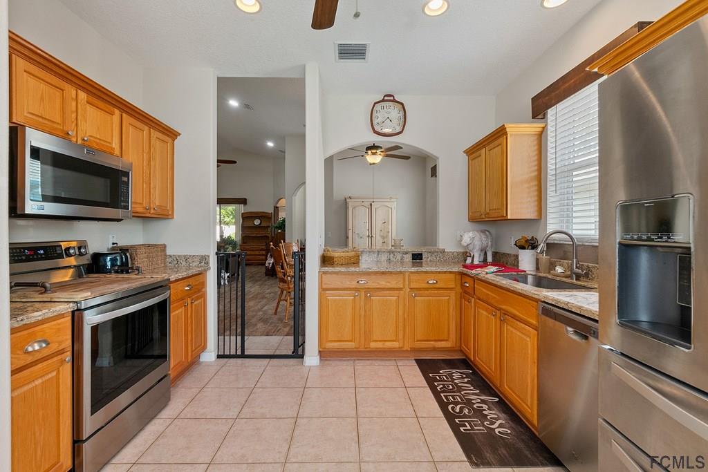 16 Raintree Circle Palm Coast, FL 32164 - Photo 18 of 45 a large kitchen with a stove top oven a sink and dishwasher