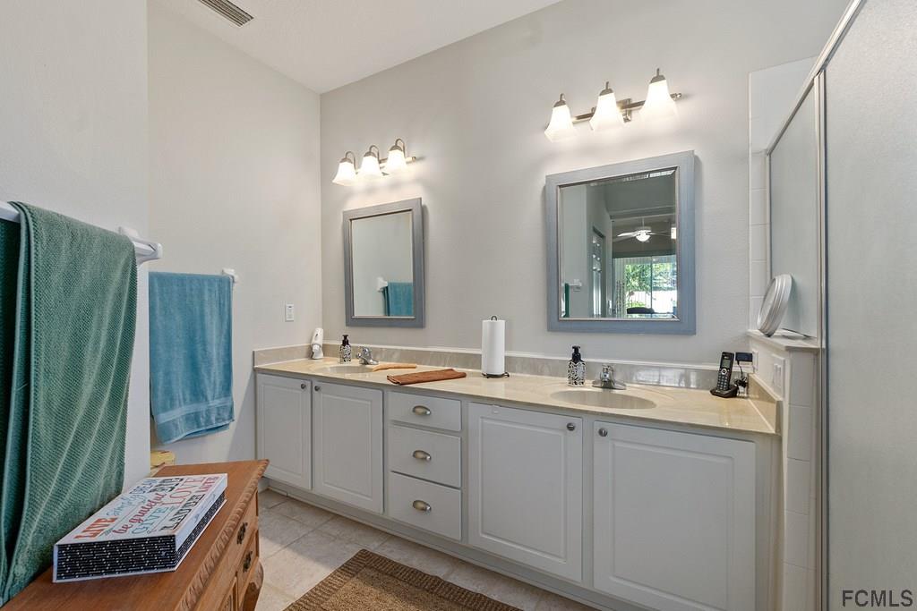 16 Raintree Circle Palm Coast, FL 32164 - Photo 30 of 45 a bathroom with a double vanity sink and mirror