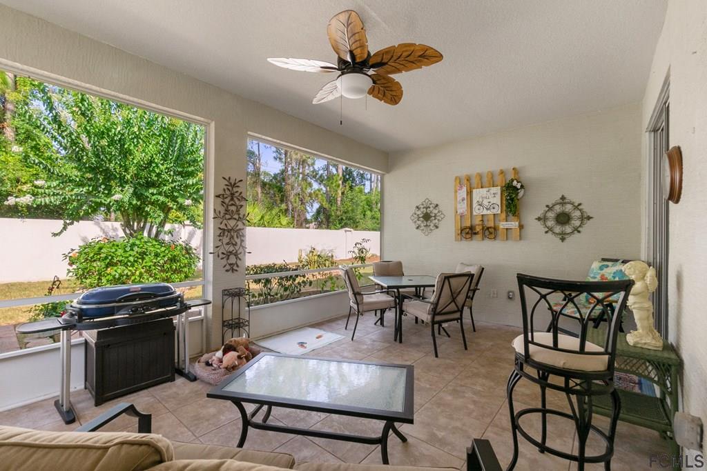 16 Raintree Circle Palm Coast, FL 32164 - Photo 37 of 45 a dining room with furniture a large window and a chandelier