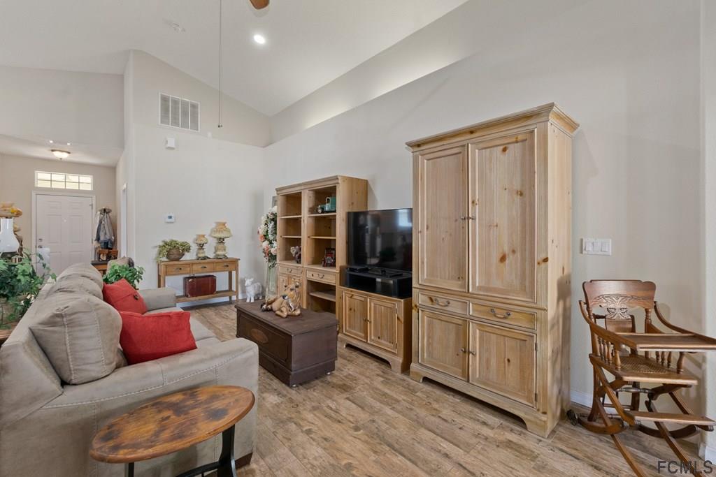16 Raintree Circle Palm Coast, FL 32164 - Photo 6 of 45 a living room with furniture a fireplace and a flat screen tv