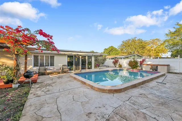 a view of a house with swimming pool and sitting area