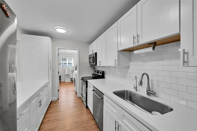 a kitchen with sink a stove and refrigerator