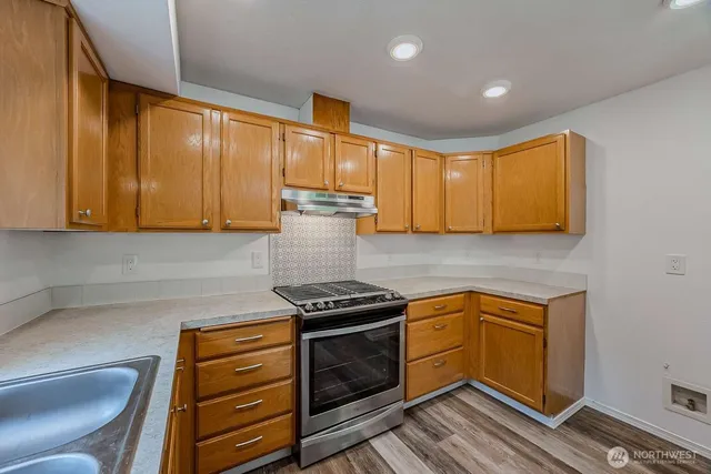 a kitchen with granite countertop cabinets stainless steel appliances and a counter space