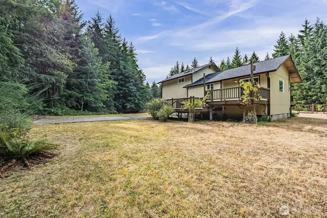 a view of a house with backyard and trees