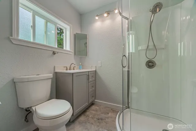 a bathroom with a granite countertop toilet sink and shower