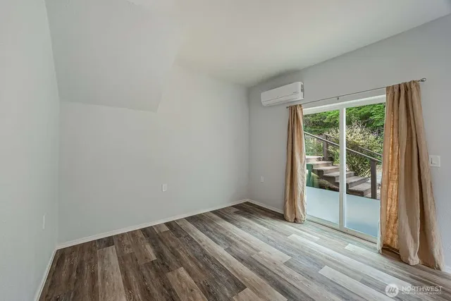 a view of a room with wooden floor and bedroom next to a window