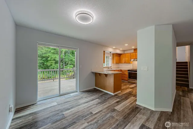 a view of a kitchen with wooden floor and a window