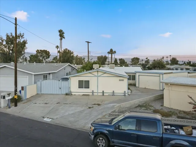 a view of a white house next to a road