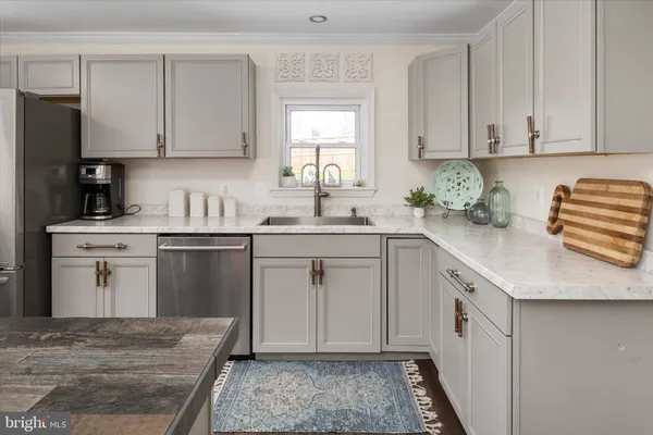 a kitchen with stainless steel appliances a stove a chimney a sink and cabinets