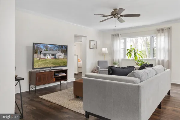a living room with furniture kitchen view and a window