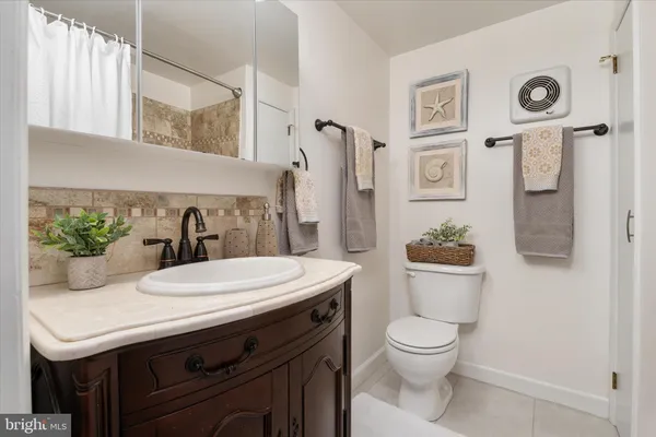 a bathroom with a granite countertop toilet sink and mirror
