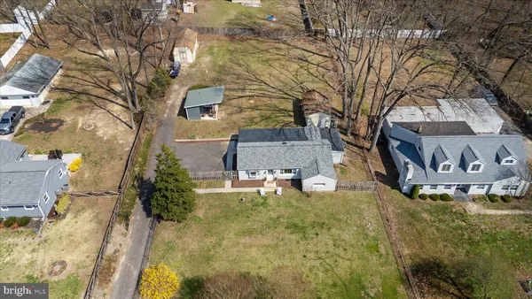 a view of a house with a yard covered in the forest