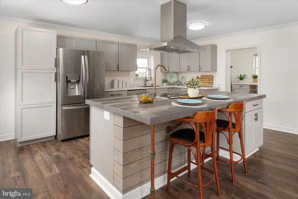 a kitchen with stainless steel appliances granite countertop a sink cabinets and wooden floor