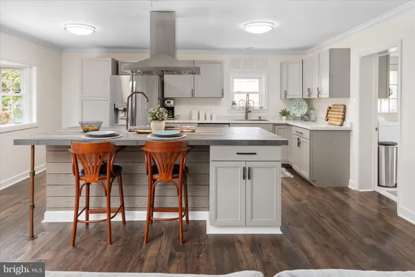 a kitchen with a sink a refrigerator and wooden floor