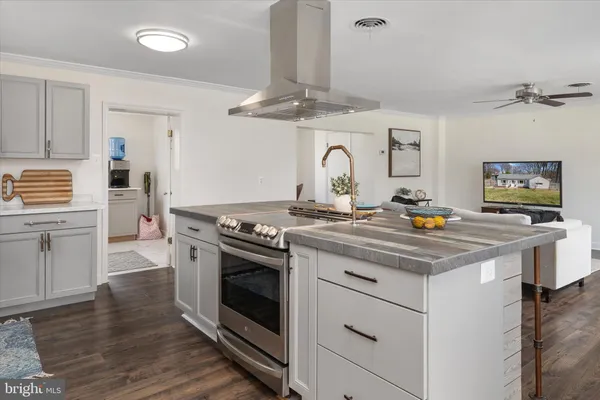 a kitchen with stainless steel appliances granite countertop wooden floor window and cabinets