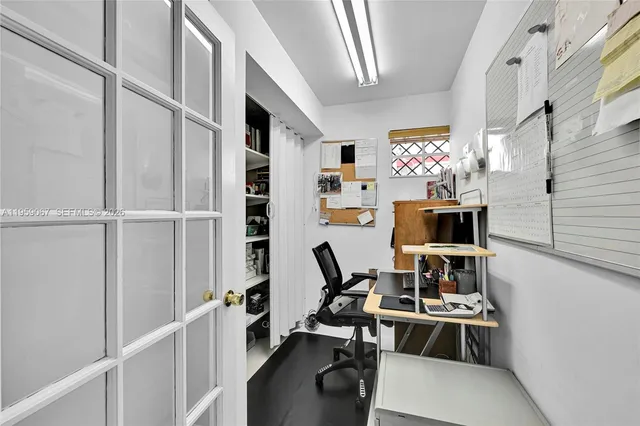 a view of a workspace with furniture and a window