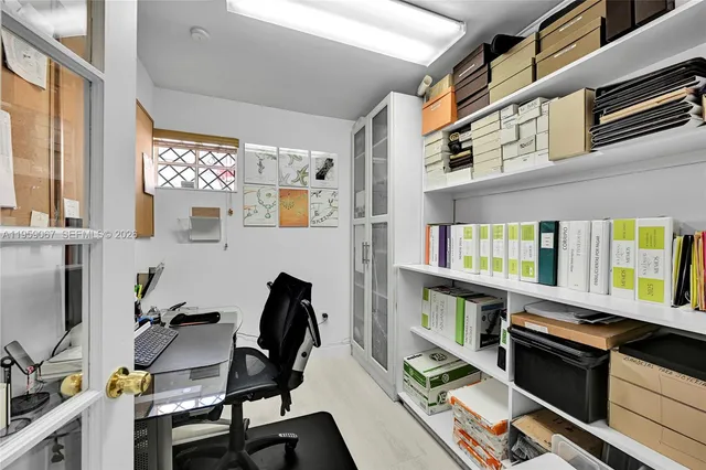 a view of a workspace with furniture and a window