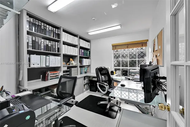 a view of a workspace with furniture and a window