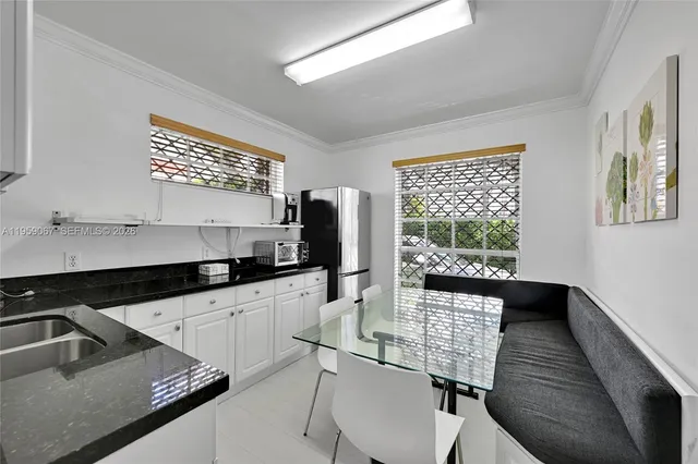 a kitchen with granite countertop a sink chairs and cabinets