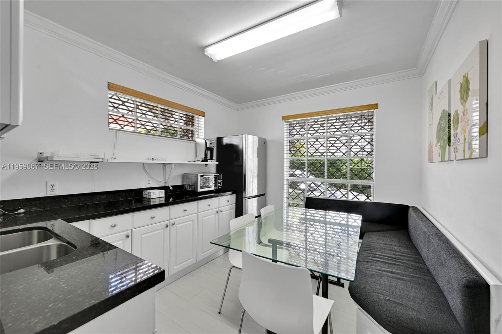 2212 Southwest 22nd Avenue Miami, FL 33145 - Photo 25 of 32 a kitchen with granite countertop a sink chairs and cabinets