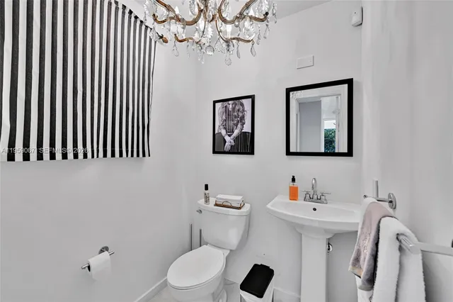 a bathroom with a sink mirror and toilet