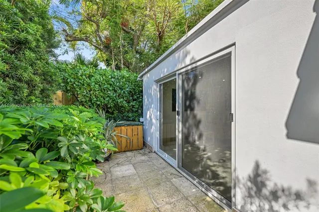 a backyard of a house with a fountain and plants
