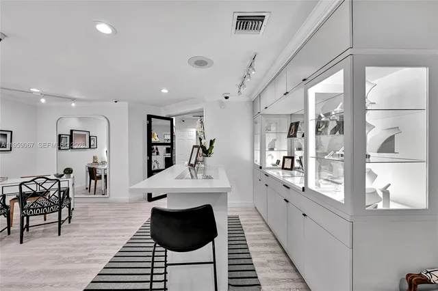 a large white kitchen with sink and wooden floor