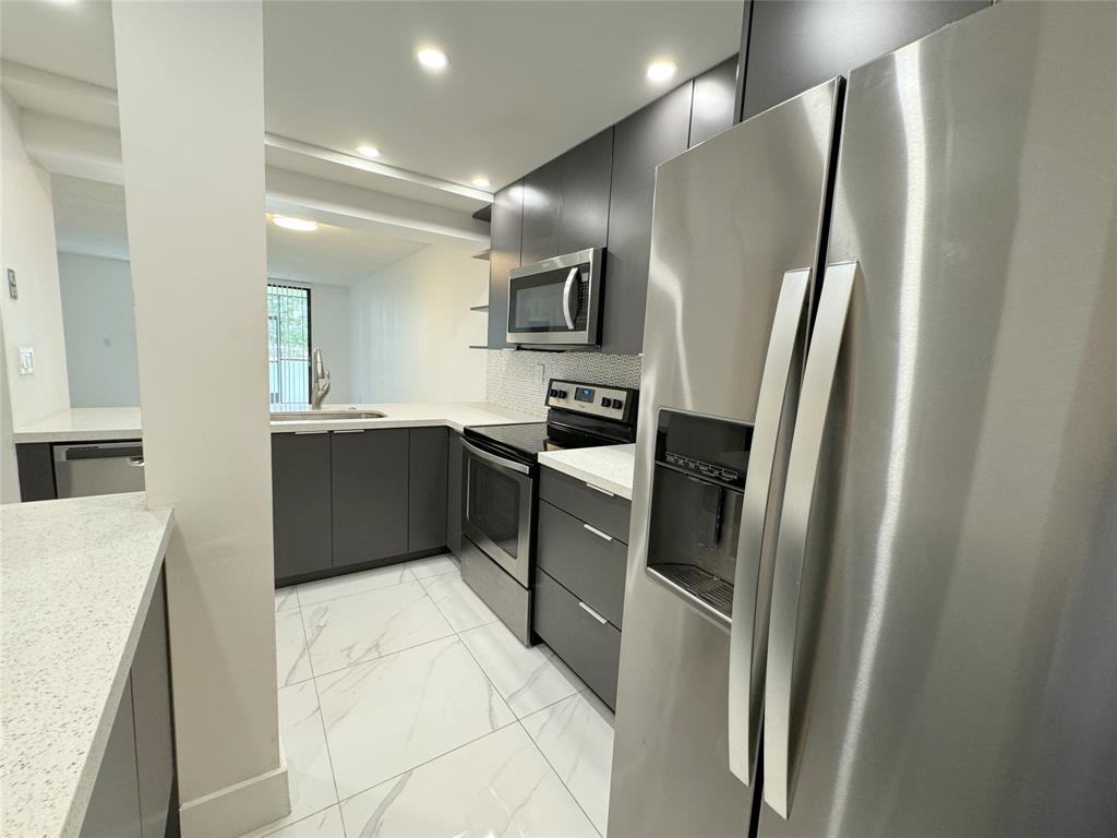 6800 Cypress Road, Unit 102 Plantation, FL 33317 - Photo 8 of 29 a kitchen with stainless steel appliances granite countertop a refrigerator and a sink