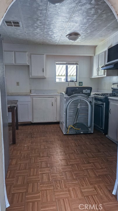 45800 Challenger Way, Unit 251 Lancaster, CA 93535 - Photo 4 of 7 a kitchen with kitchen island granite countertop a stove a sink and a refrigerator