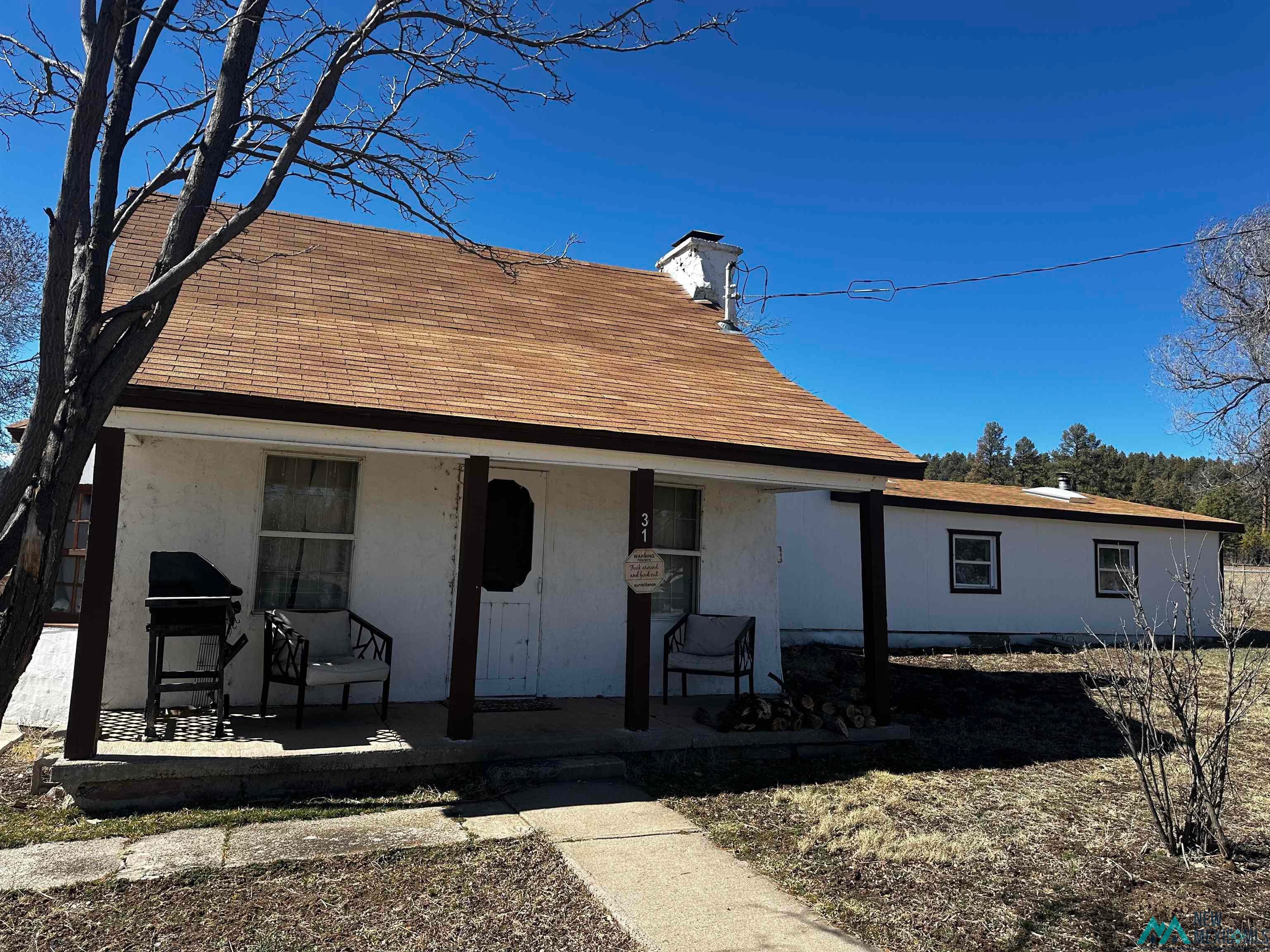 31 Bill Knight Gap Road Luna, NM 87824 - Photo 1 of 41 View of front of property featuring a chimney, a porch, and roof with shingles