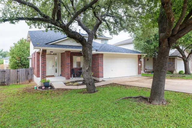 a view of a house with backyard and a tree