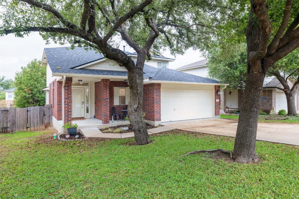a view of a house with backyard and a tree