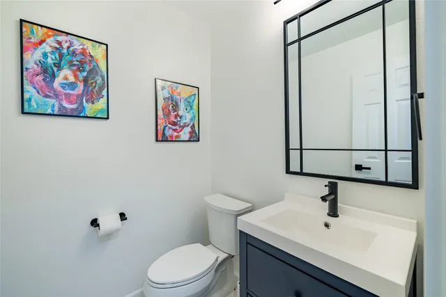 a bathroom with a sink mirror and toilet
