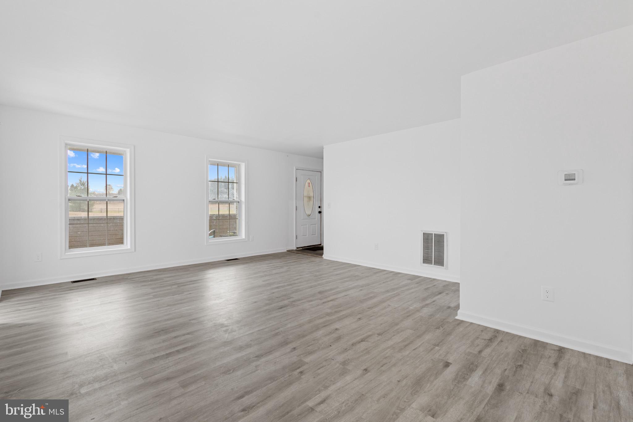 125 Oliver Guessford Road Townsend, DE 19734 - Photo 30 of 48 an empty room with wooden floor and windows