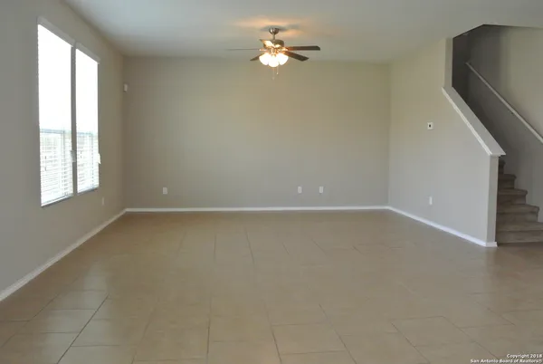 an empty room with windows and fan