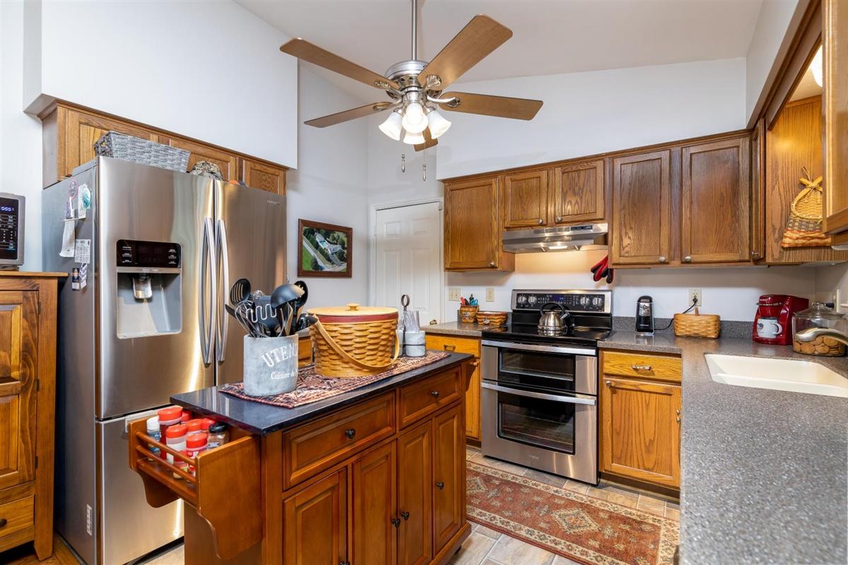 1849 Morgans Mill Road Goodview, VA 24095 - Photo 9 of 40 a kitchen with stainless steel appliances granite countertop a stove refrigerator a sink dishwasher a dining table and chairs with wooden floor