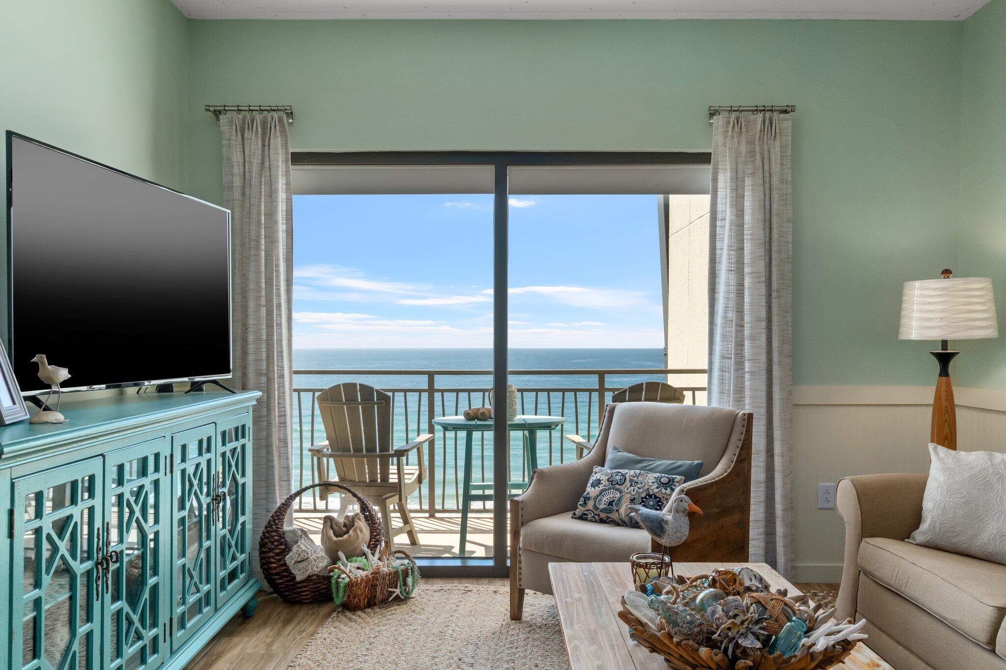 15100 Front Beach Road, Unit 1302 Panama City Beach, FL 32413 - Photo 20 of 67 a living room with furniture a flat screen tv and floor to ceiling window