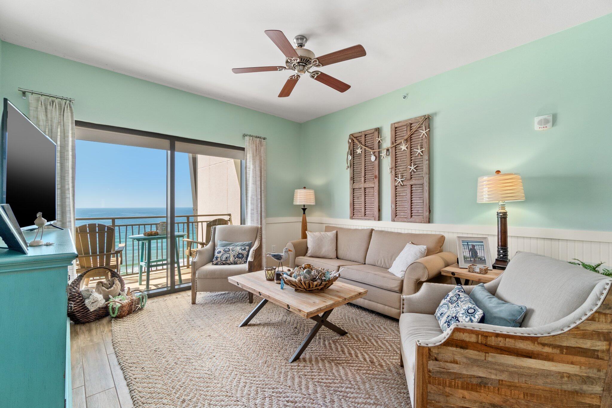 15100 Front Beach Road, Unit 1302 Panama City Beach, FL 32413 - Photo 21 of 67 a living room with furniture a flat screen tv and a large window