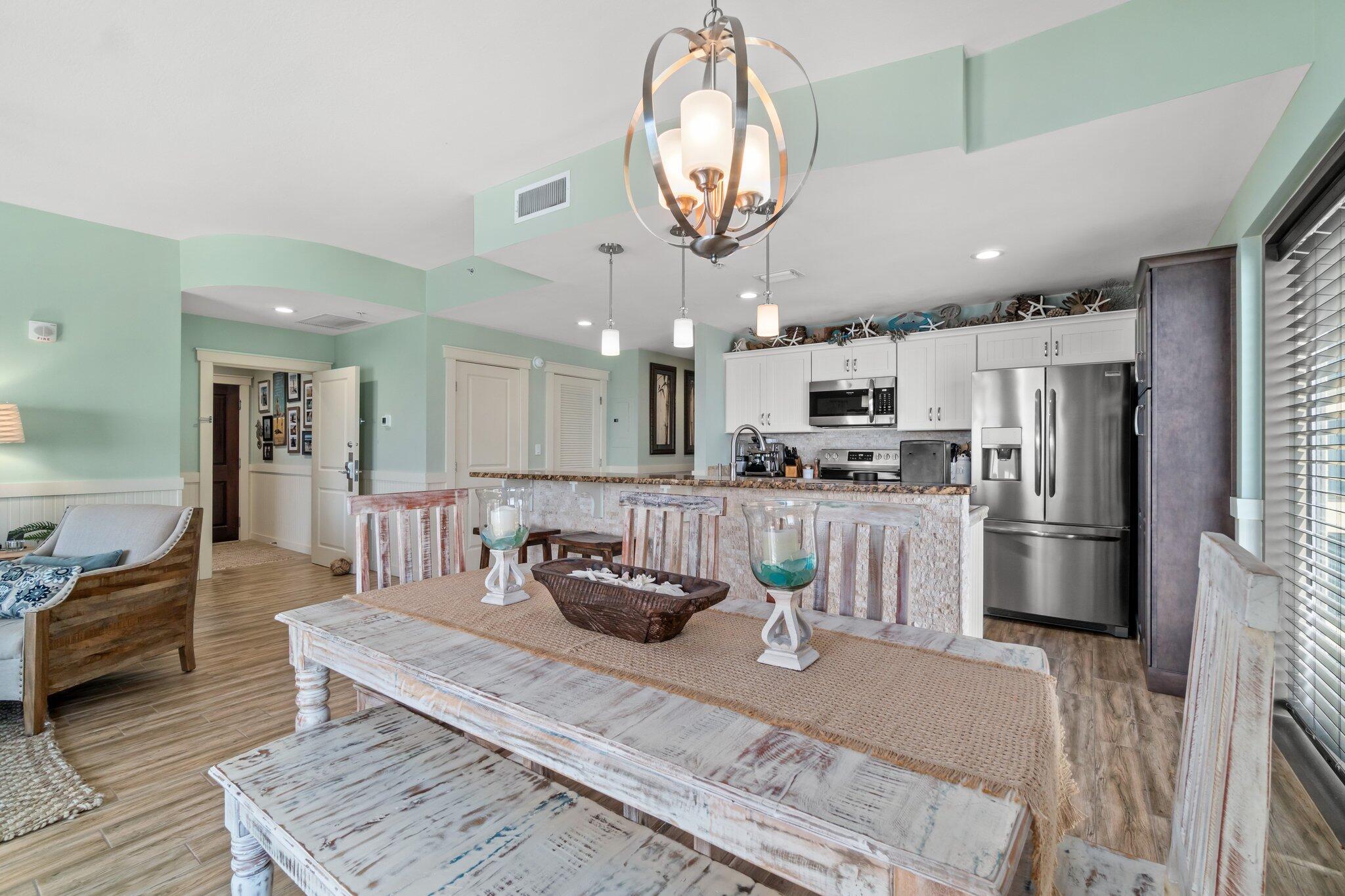 15100 Front Beach Road, Unit 1302 Panama City Beach, FL 32413 - Photo 29 of 67 a kitchen with stainless steel appliances kitchen island granite countertop a refrigerator a stove a microwave oven a sink with island and chairs