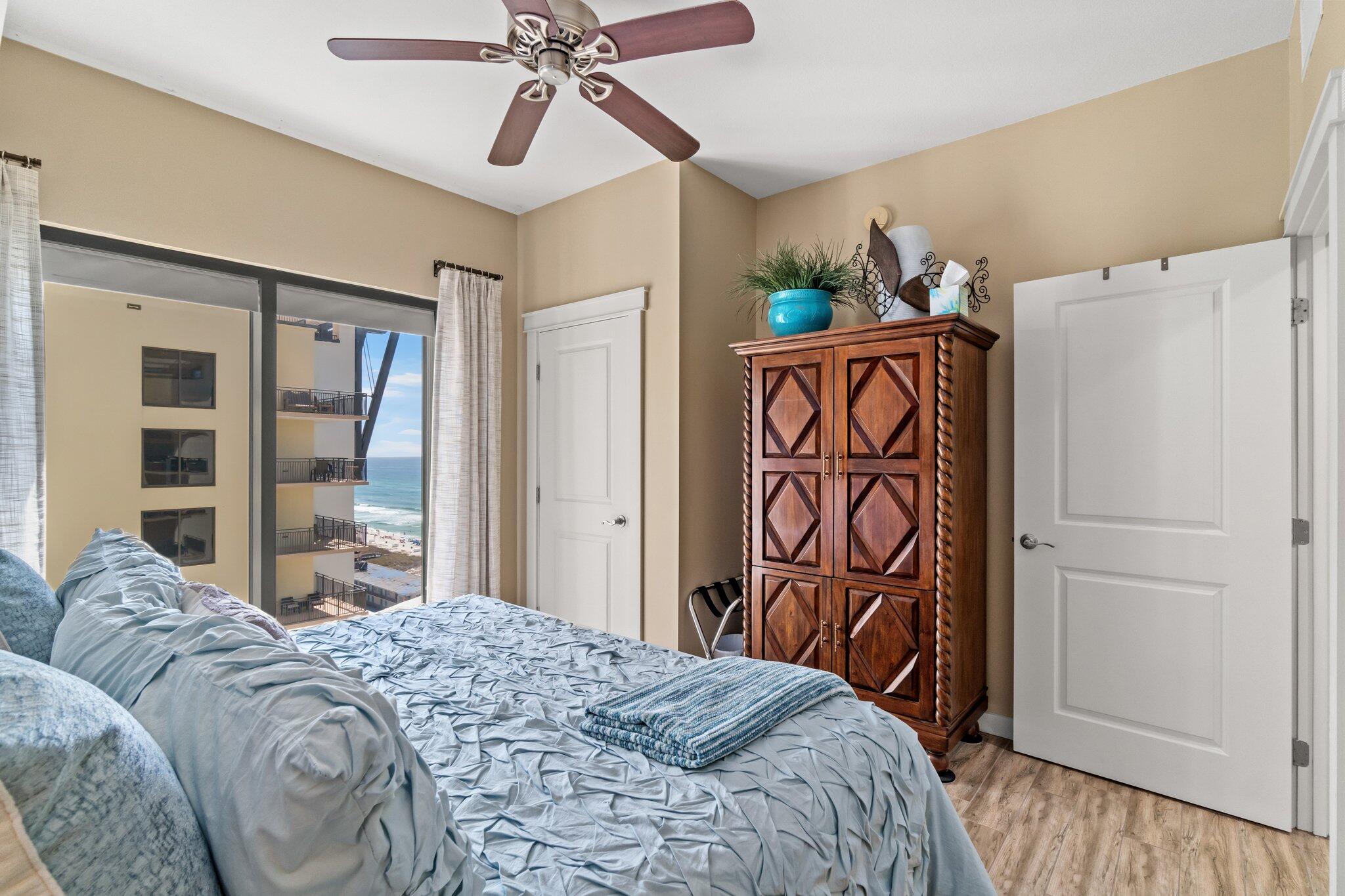 15100 Front Beach Road, Unit 1302 Panama City Beach, FL 32413 - Photo 34 of 67 a bedroom with a bed and a chandelier