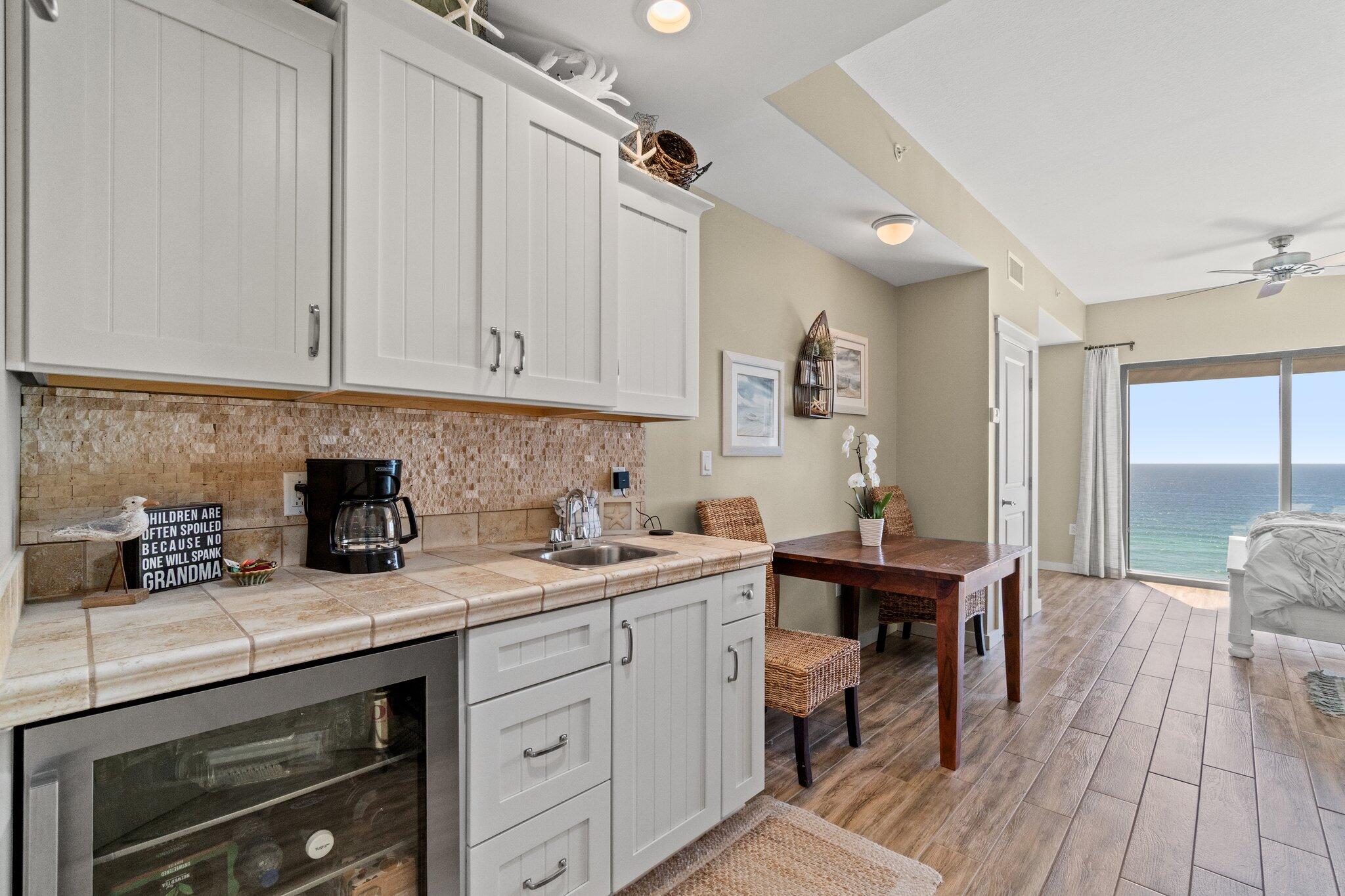 15100 Front Beach Road, Unit 1302 Panama City Beach, FL 32413 - Photo 37 of 67 a kitchen with a sink a stove and cabinets