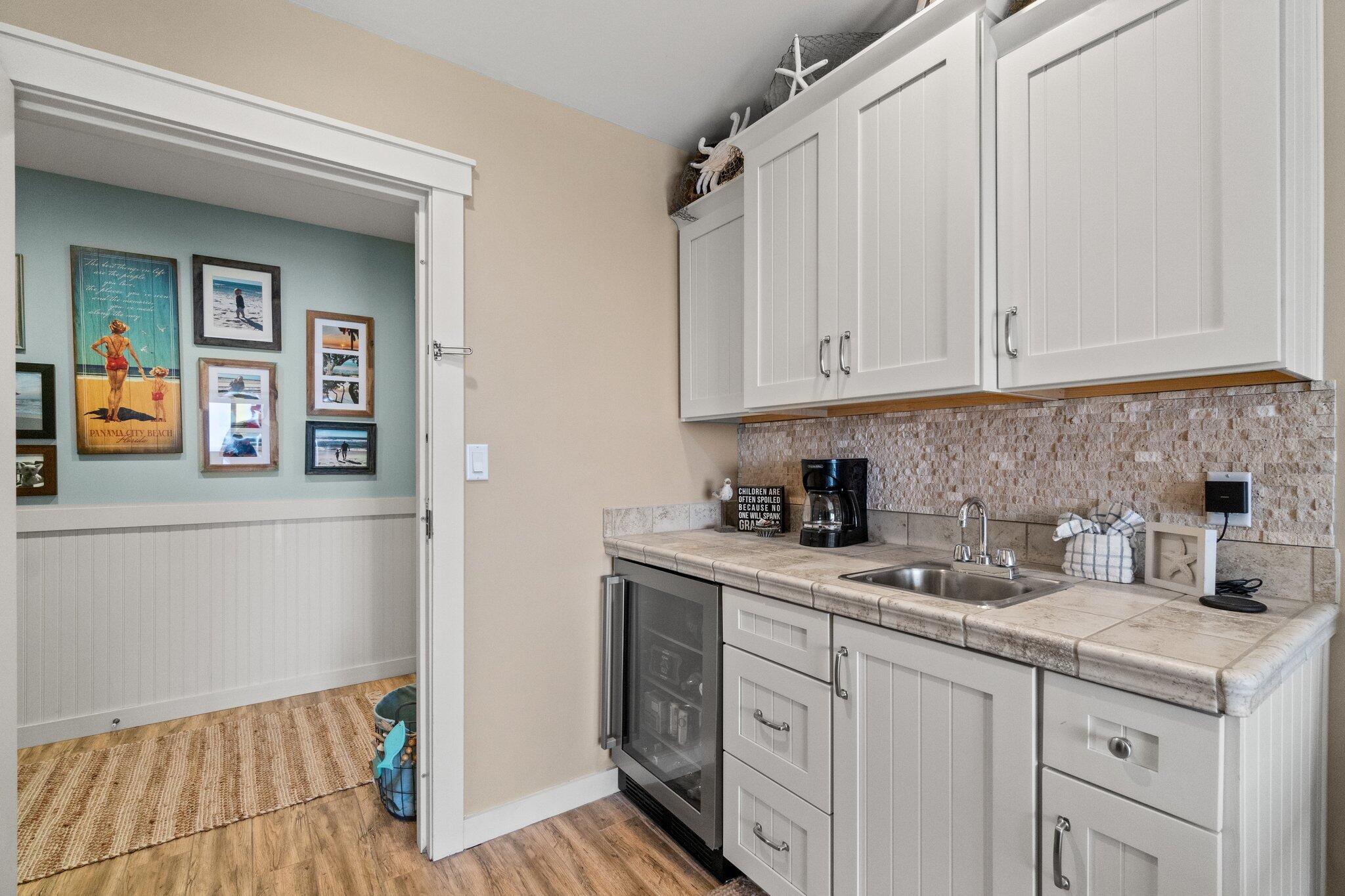 15100 Front Beach Road, Unit 1302 Panama City Beach, FL 32413 - Photo 38 of 67 a kitchen with stainless steel appliances granite countertop a sink and dishwasher with white cabinets