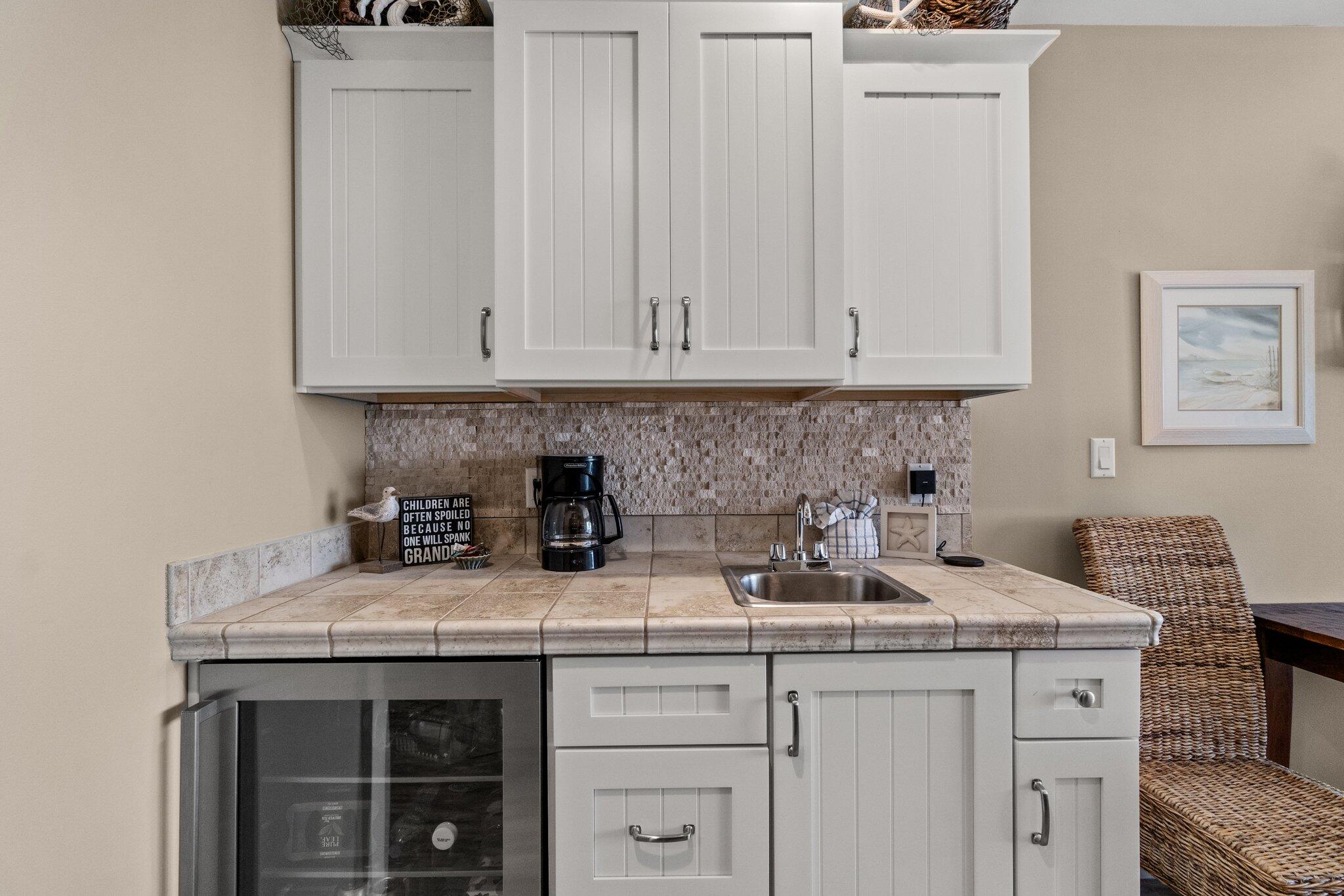 15100 Front Beach Road, Unit 1302 Panama City Beach, FL 32413 - Photo 39 of 67 a kitchen with granite countertop a sink a stove and cabinets