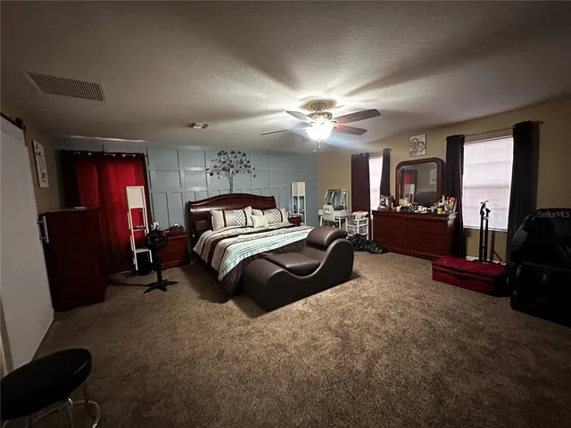 a bedroom with a bed a couch and dresser