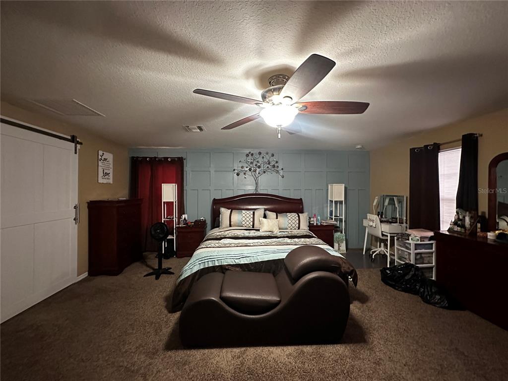 15040 Southwest 39th Circle Ocala, FL 34473 - Photo 19 of 23 a bedroom with a bed and ceiling fan