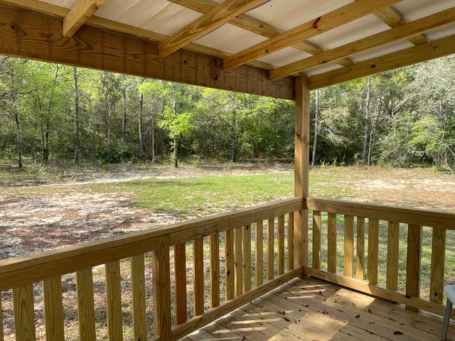 a view of a wooden deck next to a yard